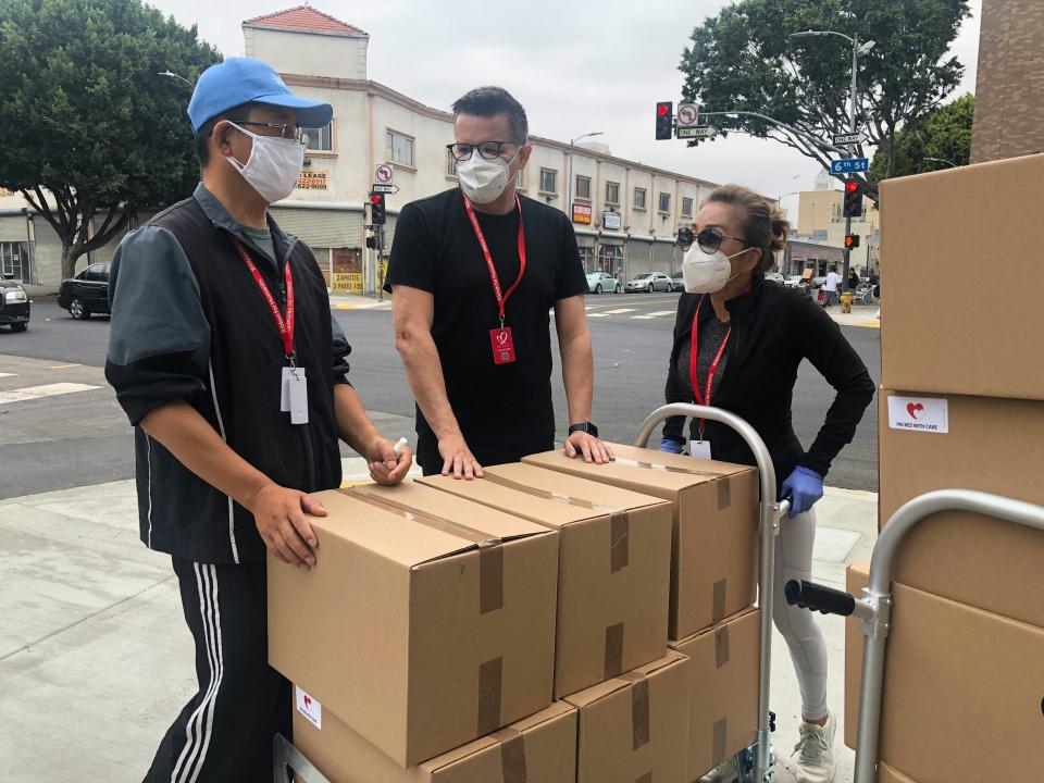 Team of workers unloading boxes with red lanyards