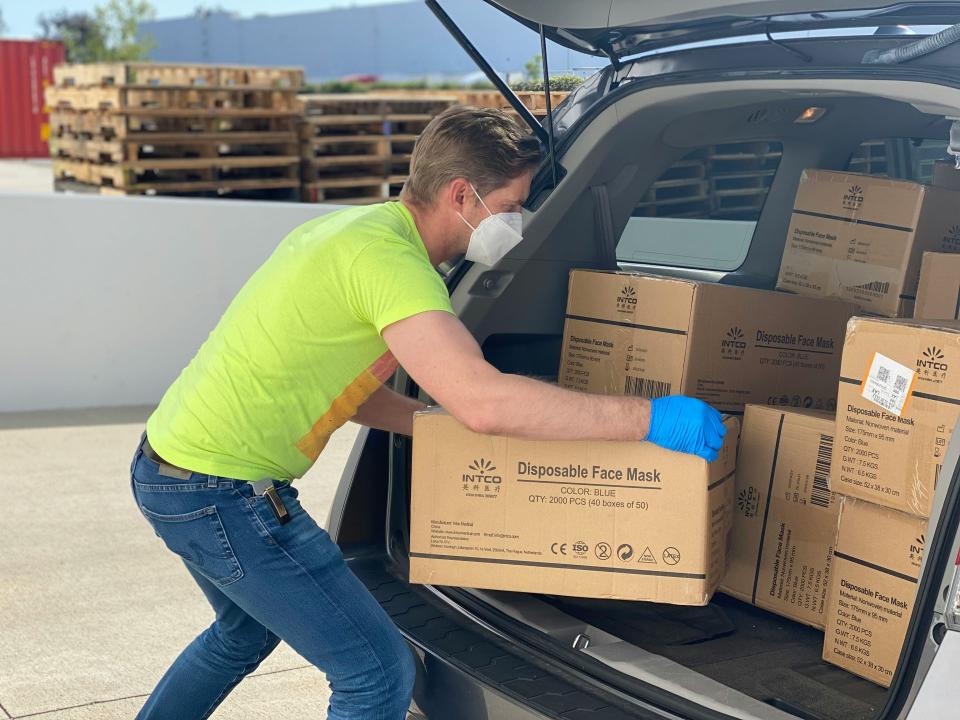 Team of workers unloading boxes with red lanyards