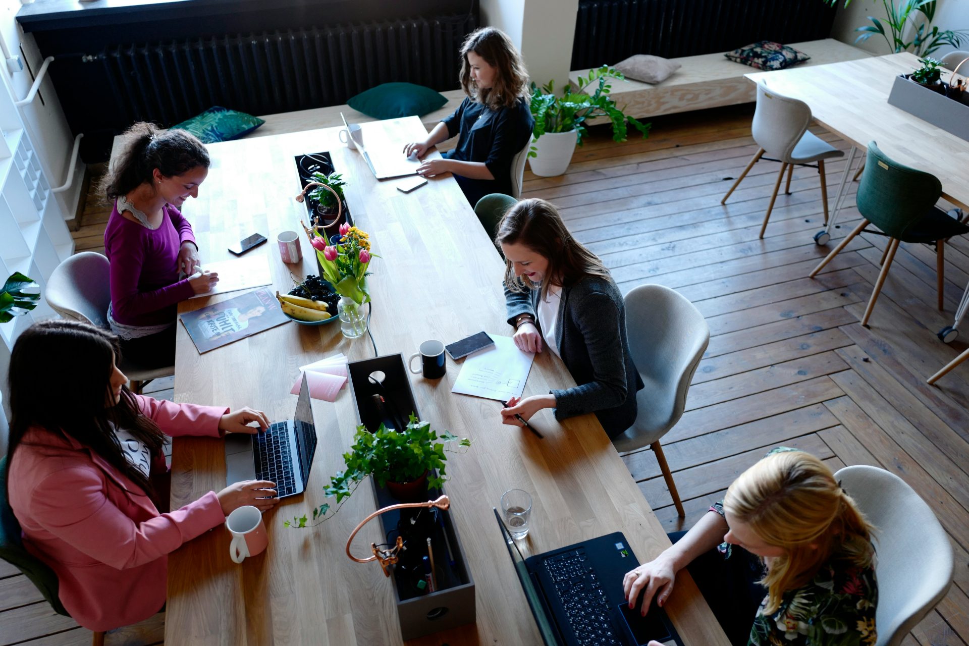 Group of people working at shared office desks.